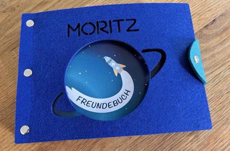 Freundebuch Weltraum geschlossen, mit blauem Filz-Cover, auf dem der Name Moritz und ein Saturn ausgelasert sind.