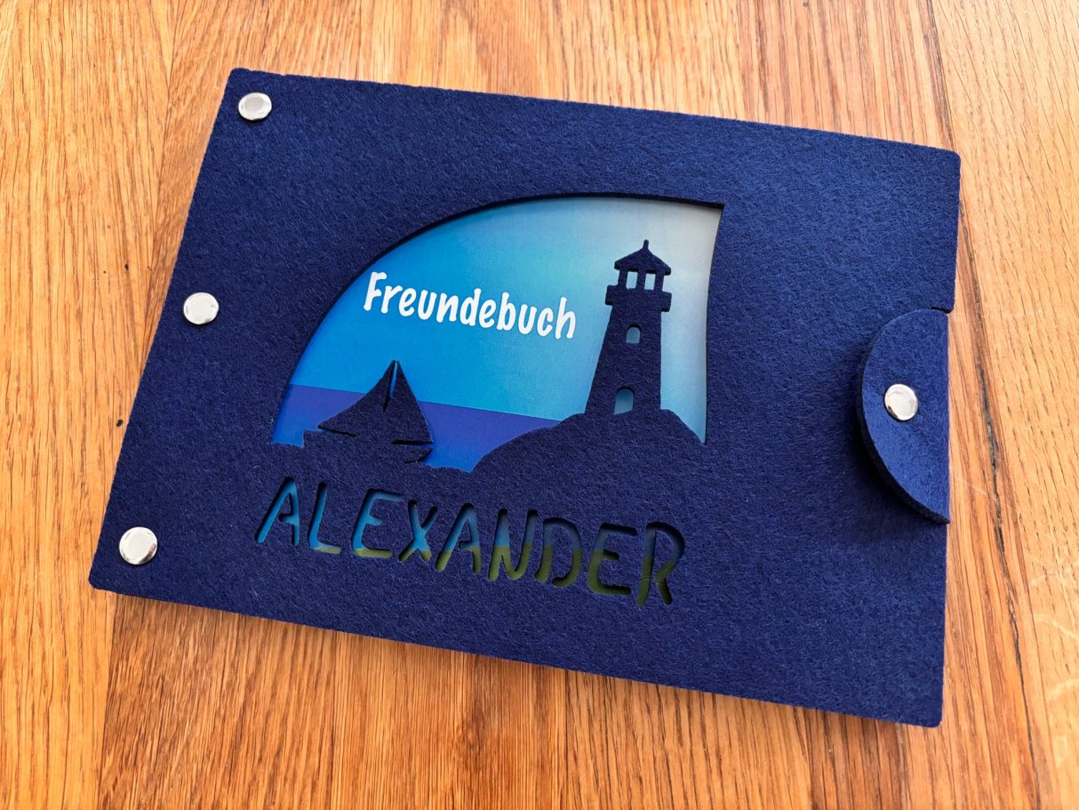 Buch mit Wellenmotiv und Leuchtturm, personalisiert mit dem Namen Alexander.