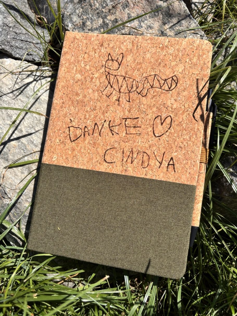 Ein Notizbuch aus Kork mit handschriftlicher Mitteilung und Herz.